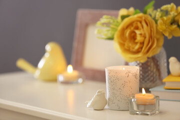 Beautiful burning candles, decor and flowers on table at home