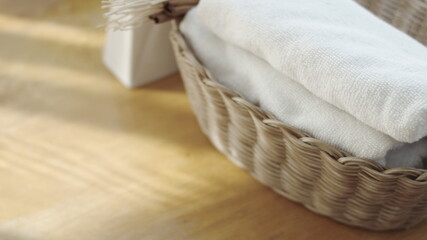 Towel placed on basket, white table top, bottle of liquid soap, spa set for bathing in the bathroom, copy space, bathroom window.