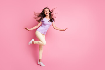 Full body photo of childish funky girl raise hands knee flowing hair dressed casual isolated on pink color background