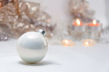 silver and white christmas ball on the table, background with decorations and copy space