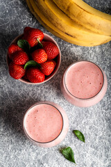Fresh smoothie with banana and strawberry in the glasses. Healthy breakfast or snack. Top view.