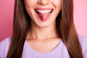 Close-up photo portrait of woman showing tongue isolated on pastel pink colored background
