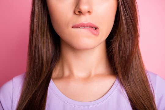 Close-up photo portrait of woman biting lower lip isolated on pastel pink colored background