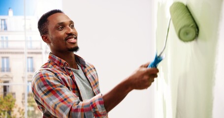 Close up portrait of happy young African American man standing in new apartment renovating room...