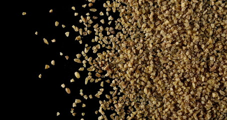 Dry bulgur pile isolated on black background, top view