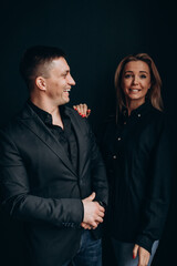 Photoshoot of a young couple in love. The solitude of a guy and a girl. Studio photography. Black background.