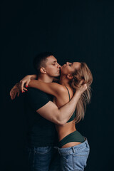Photoshoot of a young couple in love. The solitude of a guy and a girl. Studio photography. Black background.