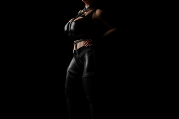 Fototapeta na wymiar Mistress in shiny black latex costume and leather straps