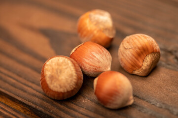 A few hazelnuts scattered on the wooden surface. Close-up, selective focus.