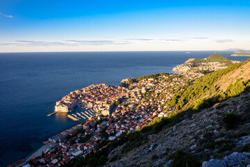 It is a landscape overlooking the walls of Dubrovnik, Croatia. The sky is blue and the blue of the Adriatic Sea is also shining.