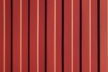 fragment of a red iron corrugated fence with bolts