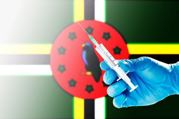 Dominica Flag Blurred Background Covid-19, Corona, Selective focused on Syringe Injection