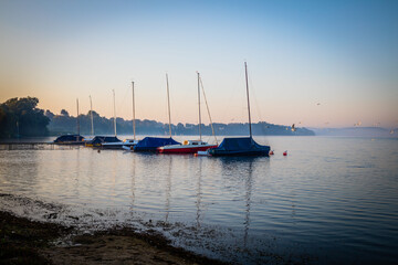 Sunrise with sailing boats at the Great Ploen lake in Schleswig-Holstein, Germany