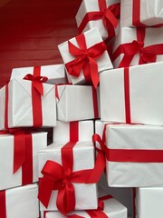 
Gift boxes wrapped in white paper and red ribbon