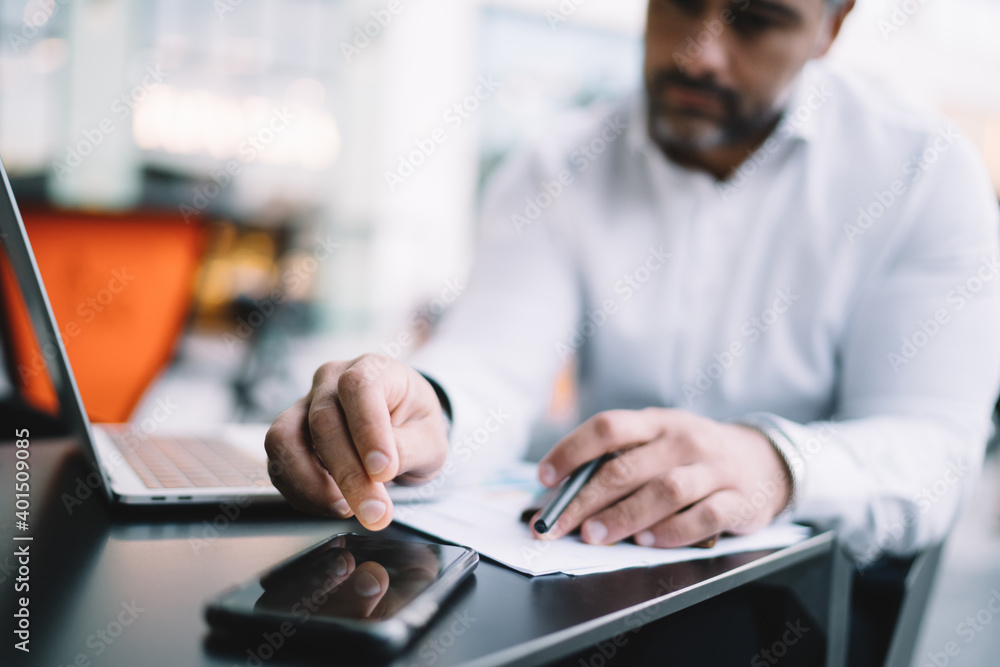 Aufkleber blurred businessman sitting at sidewalk table with netbook technology and using cellular gadget for 