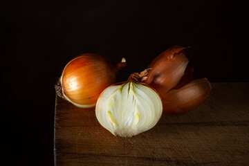 Onions on a wooden surface. Healthy vegetables. Half an onion next to a whole onion