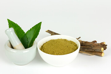 neem powder in white bowl with neem leaf in white mortar and pestle isolated on white background.