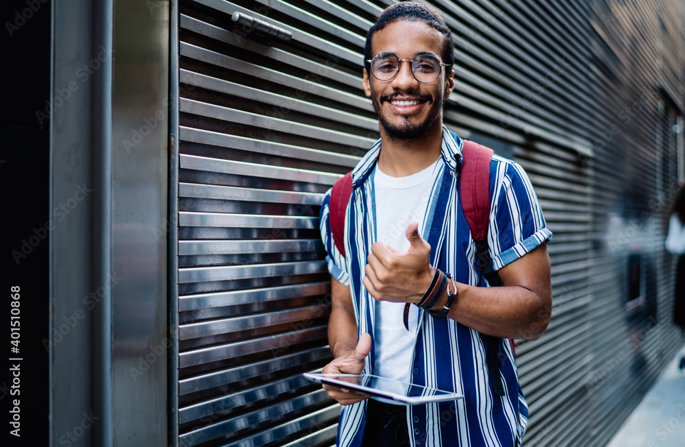 Aufkleber half length portrait of smiling dark skinned man satisfied with 4g connection for browsing via touch