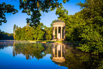 Obraz premium Pavillion reflection at sunrise in a park in Munich, Bavaria, Germany