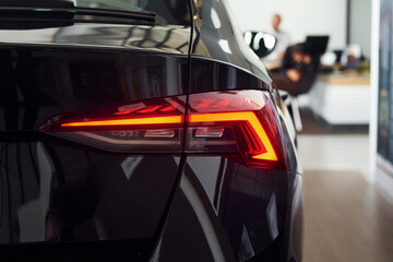 Rear view of the car. Close up focused view of brand new modern black automobile
