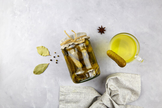 Cucumber Pickle Or Pickle Juice In Glass, A Jar With Pickled Gherkins On Grey Background,  Top View. Trend Drink, Sports Nutrition, Healthy Supplements.