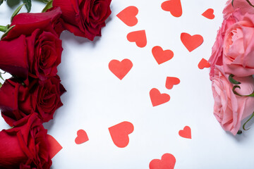 Beautiful blooming roses and hearts on a white background. View from above. Valentine's day concept.