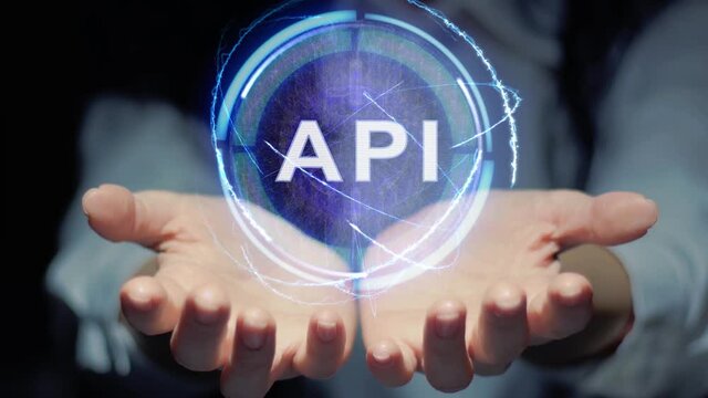 Female hands show a round conceptual hologram with text API. Unrecognizable woman in ashen white on a black background with future holographic technology
