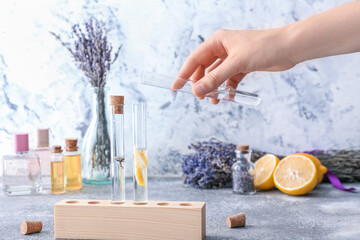 Woman preparing natural perfume on table