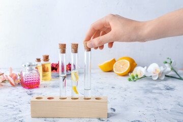 Woman preparing natural perfume on table