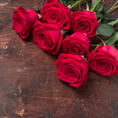 Red rose flowers bouquet on wooden background Valentine's day concept. Square. Copy space. Top view