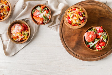 Frozen vegetables in bowls on light background