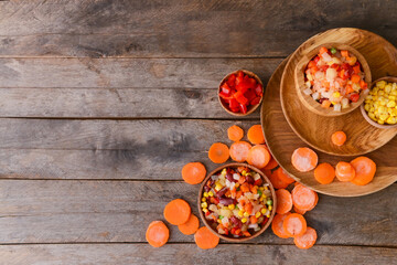 Obraz na płótnie Canvas Frozen vegetables in bowl on wooden background