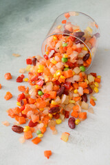 Frozen vegetables in bowl on light background