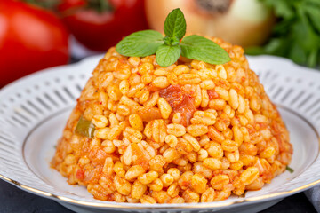 Traditional turkish bulgur pilaf with tomato sause in plate (Turkish name; meyhane pilavi)
