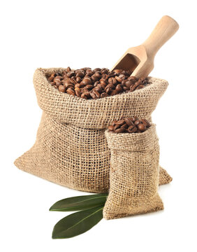 Bags with coffee beans and scoop on white background © Pixel-Shot