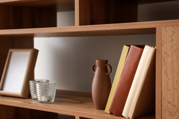 Shelving unit with books and decor in interior of room