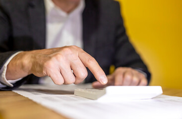 Calculating budget at office desk, close up of male hands