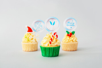 Tasty Christmas cupcakes on light background