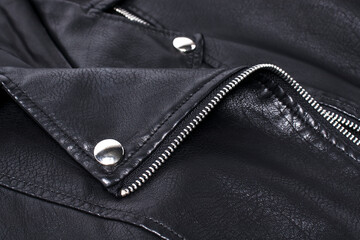 close-up detail of black leather jacket with rivets and fasteners.