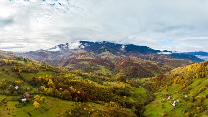 Fly over landscapes of green hills under a layer of white and fluffy clouds