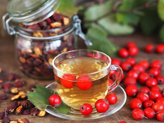 A cup of herbal healthy tea with hawthorn on a wooden background. Harvesting dried hawthorn for future use.Alternative medicine.