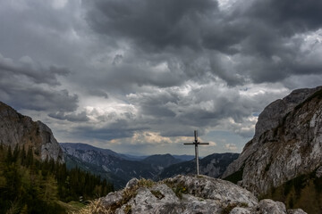 Fototapeta premium cross on a rock at the highest point of the mountain while hiking