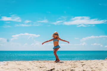 Fototapeta na wymiar happy little girl dance play on tropical beach