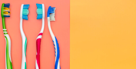 Colorful toothbrushes on a colored background, place for text