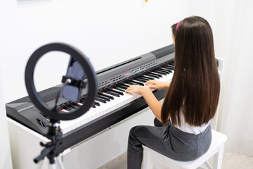 Child Girl Playing Music Keyboard Piano Instrument and shoots a video