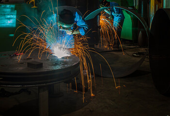 Industrial welding process is being done by a welder for metal fabrications 