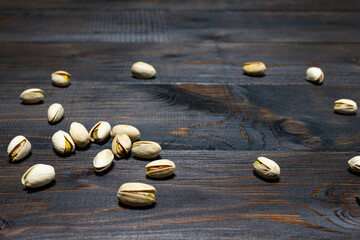 Pistachio nuts on a dark wooden background
