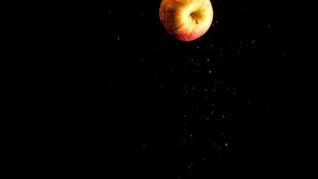 apple falling into water with air bubbles and a smooth black background. perfect for advertising or commercial videos for lemonade, juice and cocktails. Also perfect for restaurant and baar for drink