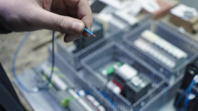 Man cutting off electrical wire with tool. Clip. Electrician with his bare hands cuts off part of electrical wire. Electrician cuts off the surface of electrical wire with special tool