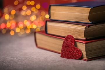Stack of books and red heart. Romantic background with the book